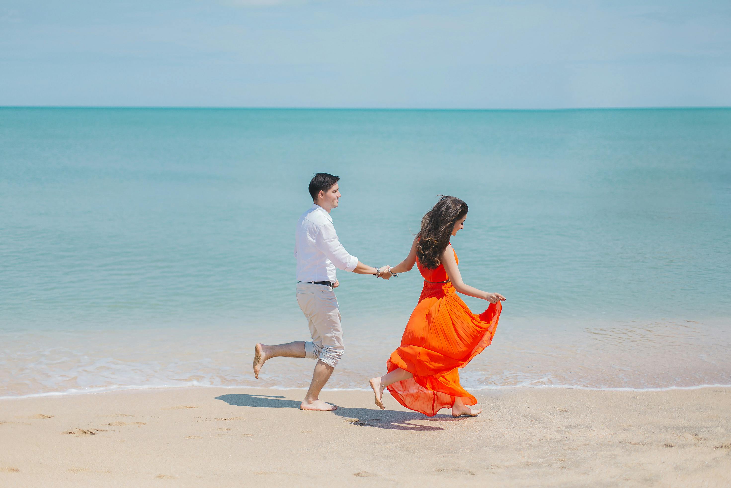 Couple joyfully running on beach