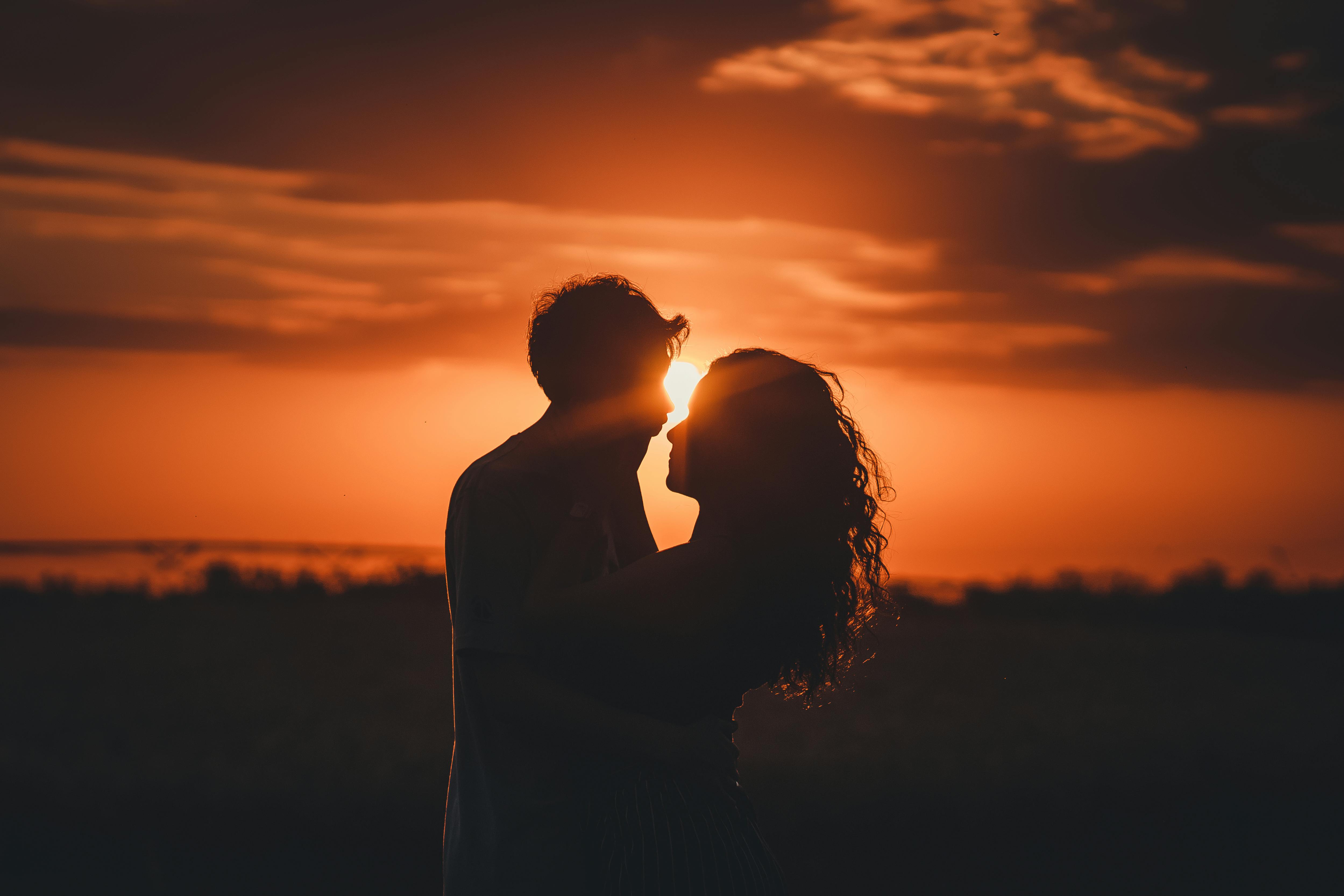 Couple silhouette embracing at sunset